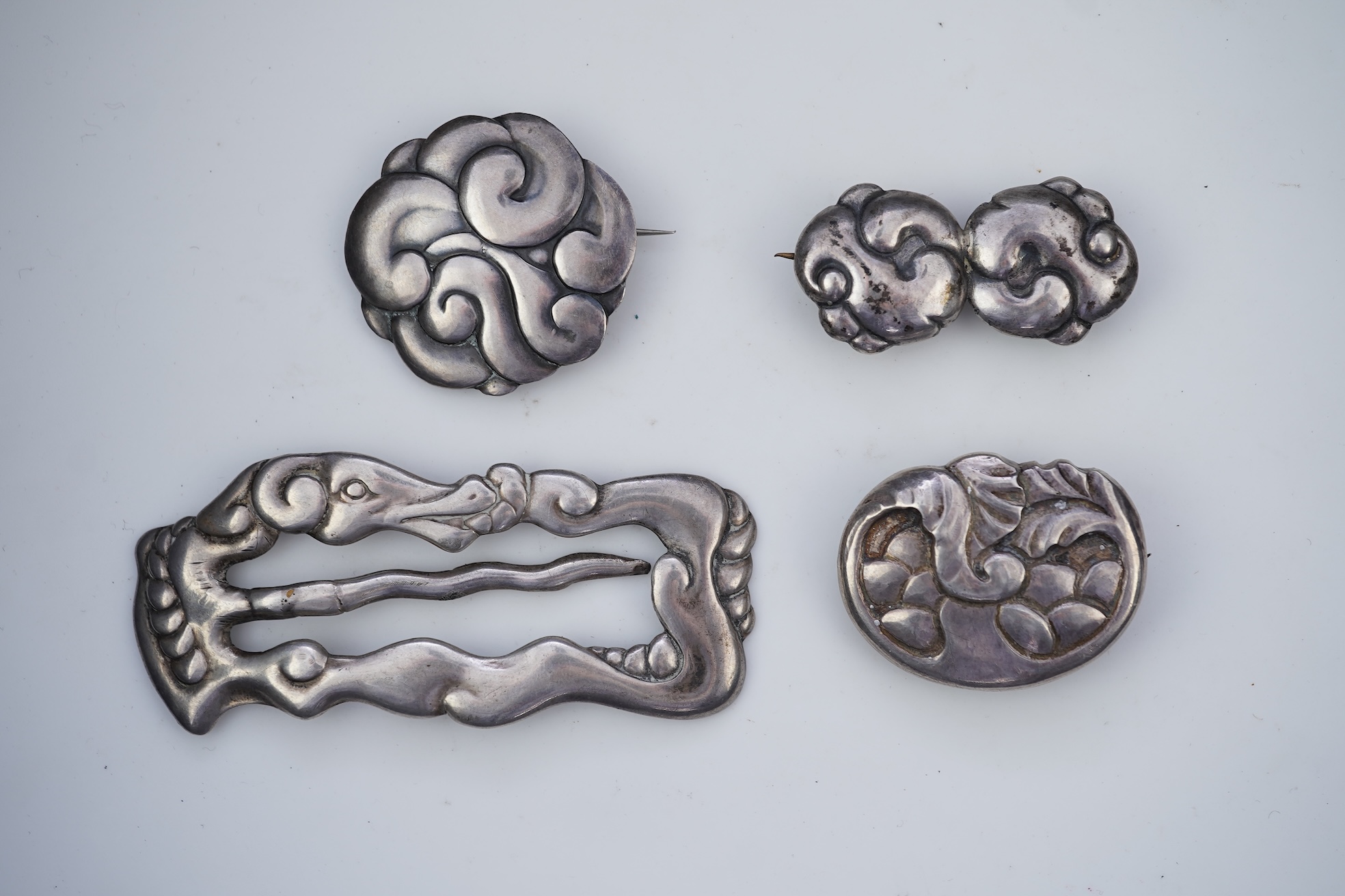 An Arts & Crafts silver slide and three silver brooches, probably Denmark, first half 20th century